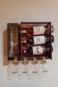 a box of wine bottles and glasses on a shelf at Chalé das Flores in Brumadinho
