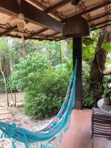 a hammock hanging from a pergola on a patio at Chalé das Flores in Brumadinho +10 photos
