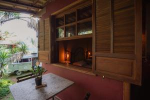 a room with a table and a window in a house at Chalé das Flores in Brumadinho
