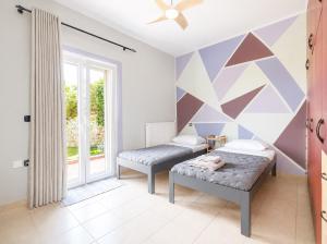 ein Schlafzimmer mit zwei Betten und einer geometrischen Wand in der Unterkunft An Drea Between in Gerani