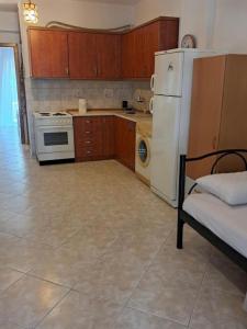 a kitchen with a white refrigerator and a stove at Evgenias Beach Escape in Kallithea Halkidikis +4 photos