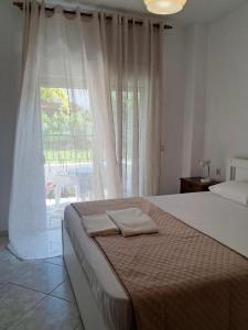 a bedroom with a bed and a large window at Evgenias Beach Escape in Kallithea Halkidikis