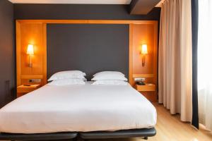 a bedroom with a large bed with two pillows at Hotel Barcelona Universal in Barcelona +113 photos