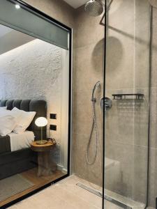 a glass shower in a bedroom with a bed at Apellou Apartments in Vathý +127 photos