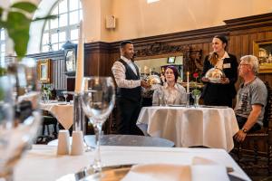 a man standing in a restaurant holding a plate of food at Schloss Purschenstein in Neuhausen +108 photos