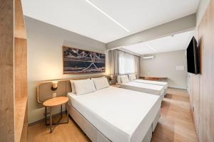 a hotel room with a bed and a tv at Slim Hotel São Paulo Congonhas in São Paulo