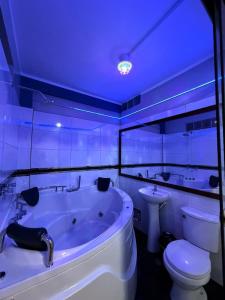 a bathroom with a tub and a toilet and a sink at Horus Suite Hotel in Jaén