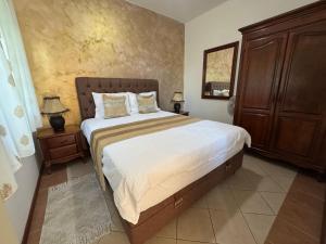 a bedroom with a large bed and a wooden cabinet at Apartments Popovic 2 in Kotor