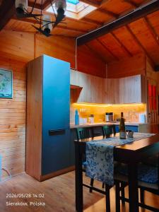 a kitchen with a blue refrigerator and a table at Słowicza Chatka in Sieraków