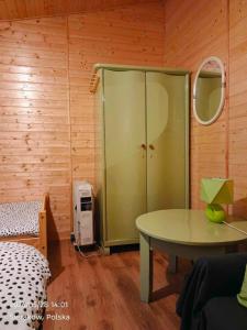 a room with a green cabinet and a table at Słowicza Chatka in Sieraków