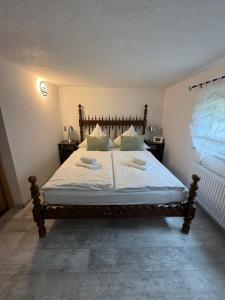 a bedroom with a bed with white sheets and pillows at Ferienwohnung Mutzelmann in Kurort Gohrisch
