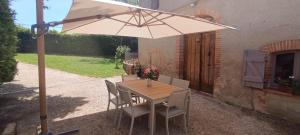a table and chairs with an umbrella on a patio at Le moulin de Christine in Saint-Nauphary +57 photos