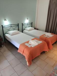 two beds sitting next to each other in a room at Odysseus Apartments in Agios Gordios