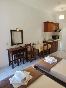 a living room with a table and a kitchen at Odysseus Apartments in Agios Gordios