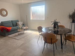 a living room with a couch and a table and chairs at Chez sana in Saint-Dizier +9 photos
