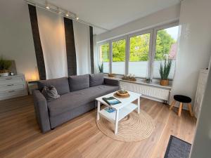 a living room with a couch and a table at Apartment Etta im Dangaster Nest in Varel