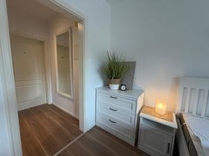 a bedroom with a bed and a dresser with a candle at Apartment Etta im Dangaster Nest in Varel