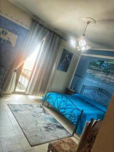 a bedroom with a blue bed and a window at Colledisisto Guest House & Restaurant in Pomarico