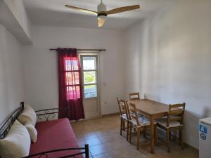 a dining room with a table and a couch at MARGARITA'S-STUDIOS in Koufonisia