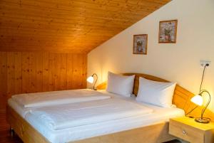 a bedroom with a large bed with two lamps at Alpenblick-Raggal in Raggal