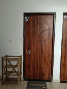 a wooden door in a room with a chair at Ojasvi Experience in Morjim +2 photos