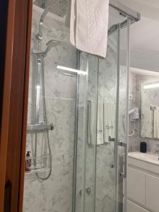 a shower with a glass door in a bathroom at Moradia Ricardo - Nazaré in Nazaré +36 photos