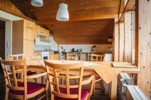 a kitchen and dining room with a wooden table and chairs at Alpenblick-Raggal in Raggal