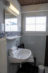 a white bathroom with a sink and a mirror at Alpenblick-Raggal in Raggal +7 photos