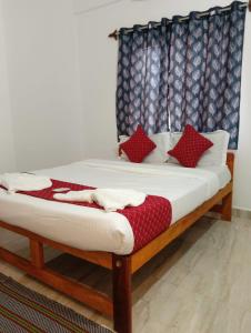 a bed with red pillows on it in a room at Ojasvi Experience in Morjim