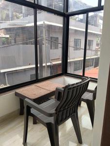 a table and a chair in front of a window at Ojasvi Experience in Morjim