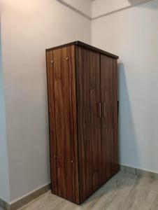 a wooden cabinet in the corner of a room at Ojasvi Experience in Morjim