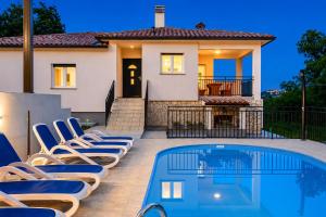a villa with a swimming pool in front of a house at House Luka by Briskva in Krapan