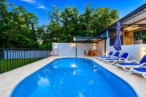 a swimming pool in a backyard with chairs and a house at House Luka by Briskva in Krapan