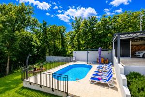 a swimming pool with lounge chairs next to a yard at House Luka by Briskva in Krapan