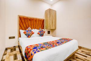 a bedroom with a large bed with a wooden headboard at FabHotel Pride Suitz in Mumbai