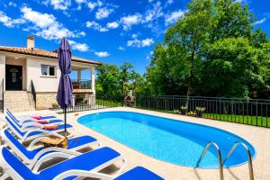 a swimming pool with lounge chairs and an umbrella at House Luka by Briskva in Krapan +29 photos