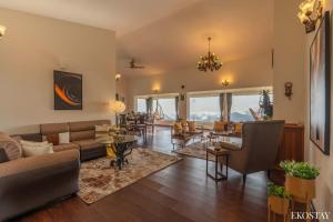 a living room with a couch and a table at EKOSTAY - Skyfall Cloud 9 Villa in Ooty