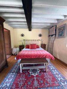 a bedroom with a bed with a red bedspread at Le moulin de la côte chambre d'hôtes in Saint-Vigor