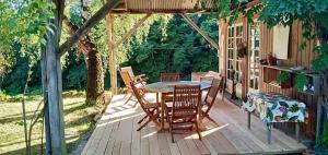 a wooden deck with a table and chairs on it at Maison La Voyageuse in Gorses