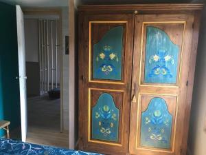 a wooden door with blue flowers on it at Maison La Voyageuse in Gorses