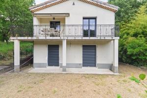 a large white house with a balcony at La Clémenguite in Vals-les-Bains