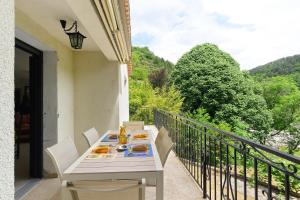 a table with plates of food on a balcony at La Clémenguite in Vals-les-Bains