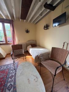 a living room with two beds and two chairs at Le moulin de la côte chambre d'hôtes in Saint-Vigor