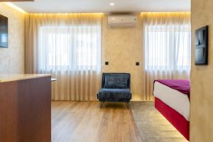 a bedroom with a bed and a chair and a desk at Lounge Inn Guest House in Porto