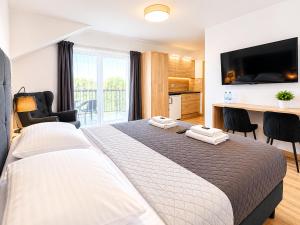 a bedroom with a large bed with a flat screen tv at ROYAL Villa RESORT & SPA - Jacuzzi, Sauna, MELEX na plażę, Masaże, Apartamenty z kuchnią, Widok na Zalew Wiślany in Krynica Morska +41 photos