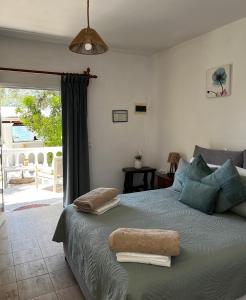 a bedroom with a large bed with towels on it at Poseidon Beach Bar & Restaurant Apartments in Paleokastritsa
