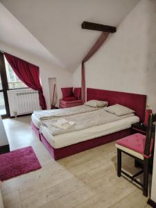 a bedroom with a large bed and a chair at RILA 6ATO Hotel & Restaurant in Panichishte