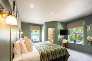 a bedroom with green walls and a bed with pillows at Tyn-y-Coed Inn in Betws-y-coed