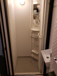 a small white refrigerator in a small bathroom at Nozawa Onsen BASECAMP in Nozawa Onsen +143 photos