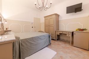 a bedroom with a bed and a desk and a tv at Ospitalità Deluxe Castello Vassallo in Stella Cilento